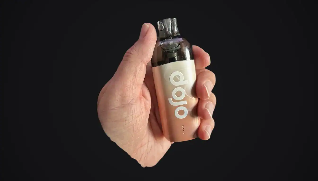 Dojo Blast 10K Fresh vape device held in hand against black background, showing peach-colored body with white logo